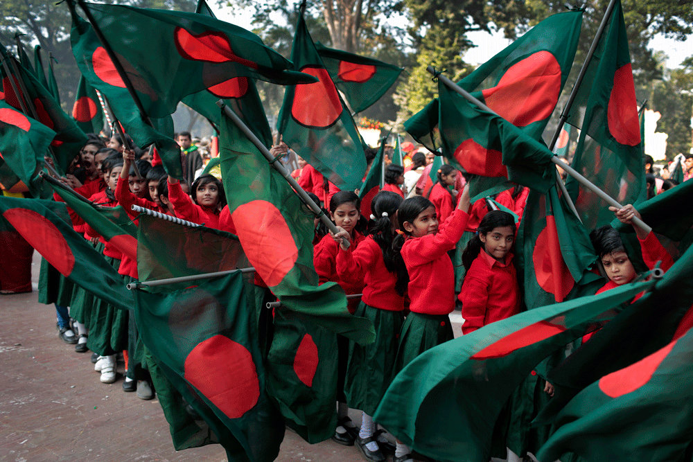 Bangladeshi children wave national flags at a rally to mark Victory Day in ...